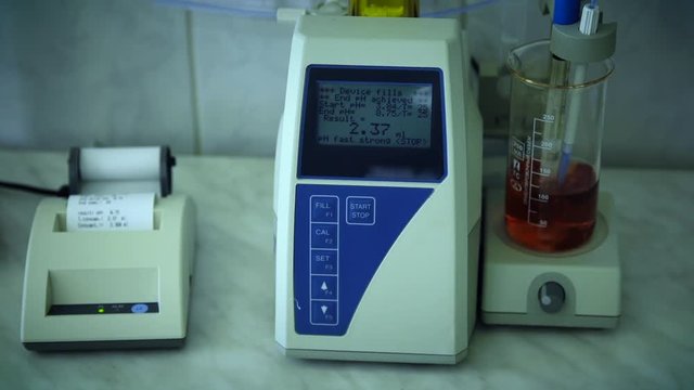 PH analysis of oil or dark lager beer. Research lab assorted glassware equipment. Schwarzbier. Printing check result