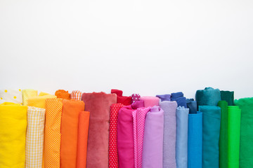 Rolls of bright colored fabric on a white background.