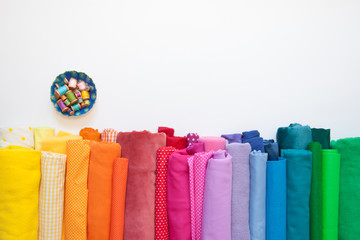 Rolls of bright colored fabric on a white background. - obrazy, fototapety, plakaty