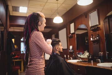 Female barber styling customer hair