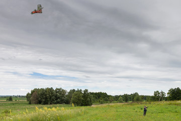 Boy launches kite on meadow