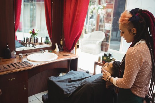 Man receiving a face massage from a female barber