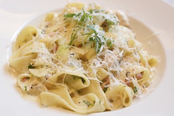 Tagliatelle pasta with cheese sauce, bacon, parsley and Parmesan