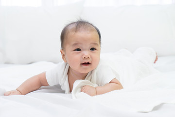 Portrait of a newborn Asian baby on the bed