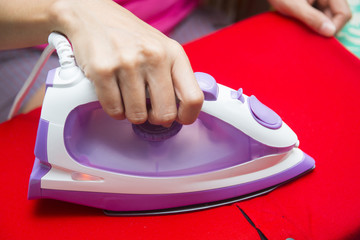 hand Ironing red shirt on ironing board