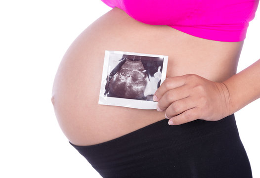 Pregnant woman hands holding ultrasound photo on white backgroun