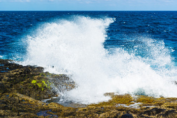Waves from the Atlantic Ocean crashing against cliffs on the volcanic landscape.  Lanzarote. Canary Islands. Spain