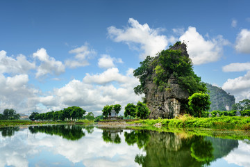 Fototapeta na wymiar Beautiful natural karst tower reflected in the Ngo Dong River