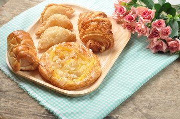 Bakery Bread on a Wooden Table. Homemade bakery on wooden dish and fabric background. Food made from flour on the wooden background.