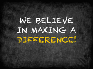 Fototapeta na wymiar We believe in making a difference - text on chalkboard