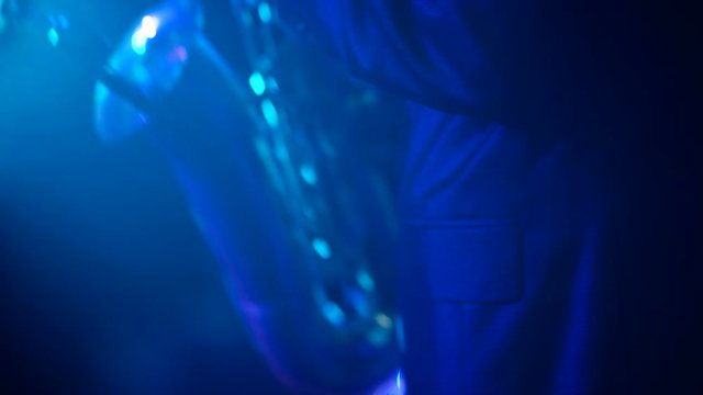 Musician is playing on saxophone in night club