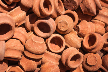 A pile of handmade clay terracotta pots on sale at a street market in India.