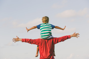 happy father and son playing on sky