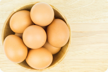Eggs in wooden bowl isolated on white background