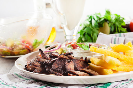Grilled meat with French fries and fresh vegetables