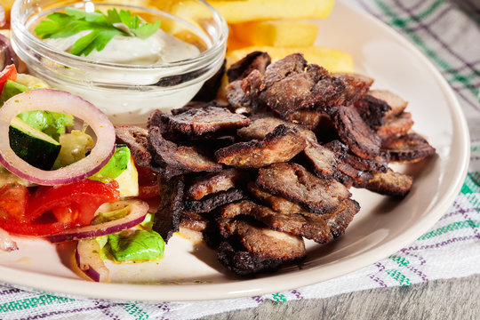 Grilled meat with French fries and fresh vegetables