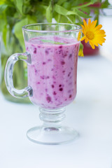 Summer juicy berry smoothie cocktail with mint leaves. Glass of fresh cool berry cocktail and summer sunny mood. Bright and delicious smoothie for a healthy vegan diet and nutrition.