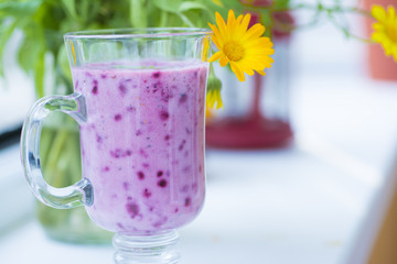 Summer juicy berry smoothie cocktail with mint leaves. Glass of fresh cool berry cocktail and summer sunny mood. Bright and delicious smoothie for a healthy vegan diet and nutrition.
