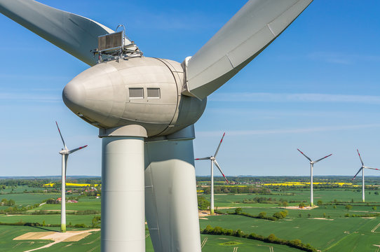 Luftbild und Nahaufnahme einer Windenergieanlage in einem Windpark mit Rapsfeld