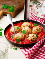 chicken meatballs with tomato sauce in a frying pan. style vintage
