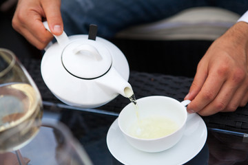 man pours tea from a teapot