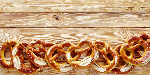 Wide angle border of Bavarian pretzels on wood