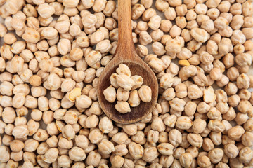 Raw chick peas background and a wooden spoon
