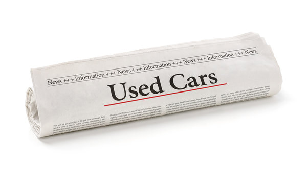 Rolled newspaper with the headline Used Cars