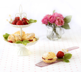 Cream puffs cakes or profiterole filled with whipped cream served with strawberries in plateau