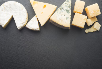 Different varieties of cheese on a black board