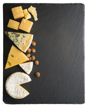 Different varieties of cheese on a black board.