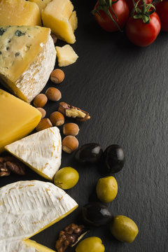 Different varieties of cheese on a black board