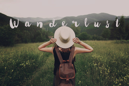 wanderlust text sign concept, hipster traveler woman holding hat