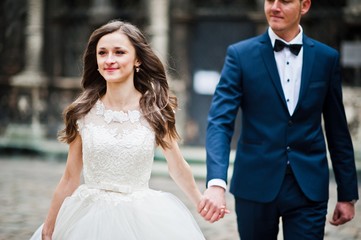 Naklejka premium Wedding couple walking on streets old city Lviv