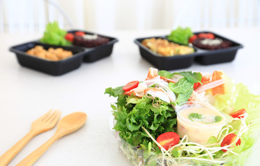 Fresh spring salad with tomato, cabbage, sunflower seeds and sprouts in a bowl on the table.