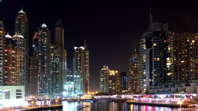 Dubai Jumeira Marina life Night view time-lapse video 4k. Skyscrapers modern buildings reflect in water Travel tourism Real Estate business in United Arab Emirates time lapse.