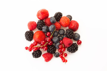 mixed red and black fruit in a circle on a white background