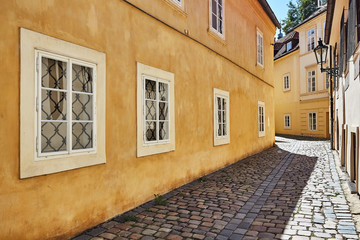 Empty historical tight street with stone path in sunny day in old city of Prague