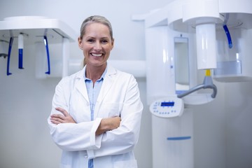 Portrait of female dentist smiling with arms crossed