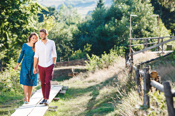 Naklejka na ściany i meble Lovely couple walking together in the countryside