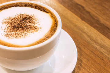 Closeup white cup of coffee on wood table.