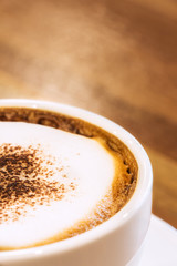Closeup white cup of coffee on wood table.