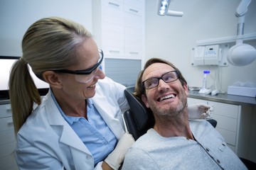 Obraz premium Female dentist interacting with male patient