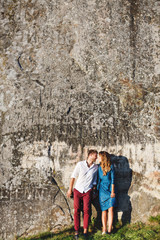 Cute couple standing near stone wall