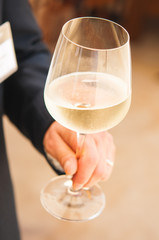 Business man holding a glass of white wine