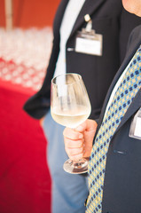 Business man holding a glass of white wine