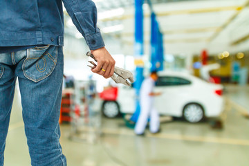 Hand with wrench. Auto mechanic in car repair