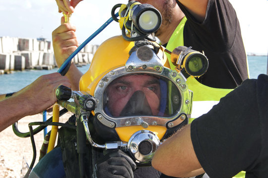Photo of a diver who is willing to dive - he is dressed in a suit and helmet