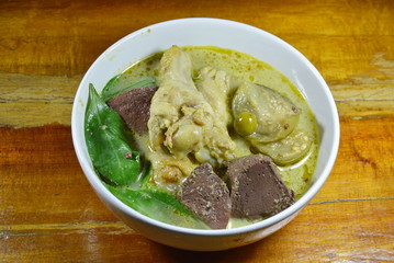 spicy chicken leg in green curry on bowl