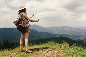 Fototapeta premium stylish hipster woman traveler with backpack holding map and exp